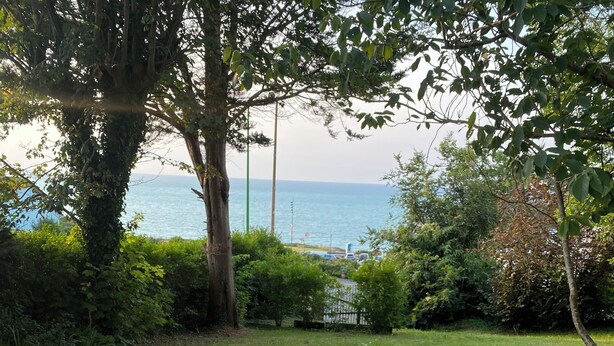 A deck with a table set for a meal, overlooking a body of water. - Vacation home "Bord de Mer" - Exceptional sea view (Petit-Caux)
