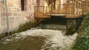 Un bâtiment en pierre avec un escalier en bois menant à un balcon.