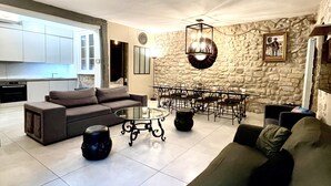 Un salon moderne avec un canapé, une table basse et un coin repas.