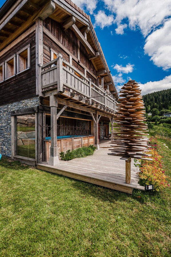 A wooden house with a balcony, a stone wall, and a wooden staircase. - Chalet with lake view and ski-out - Sauna and pool (Gérardmer)