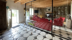A modern interior with a hexagonal tile floor, wooden ceiling beams, a glass partition, and a red sofa. - BRITTANY FINISTERE CROZON PENTY SPACIOUS AND LUMINOUS (Crozon)