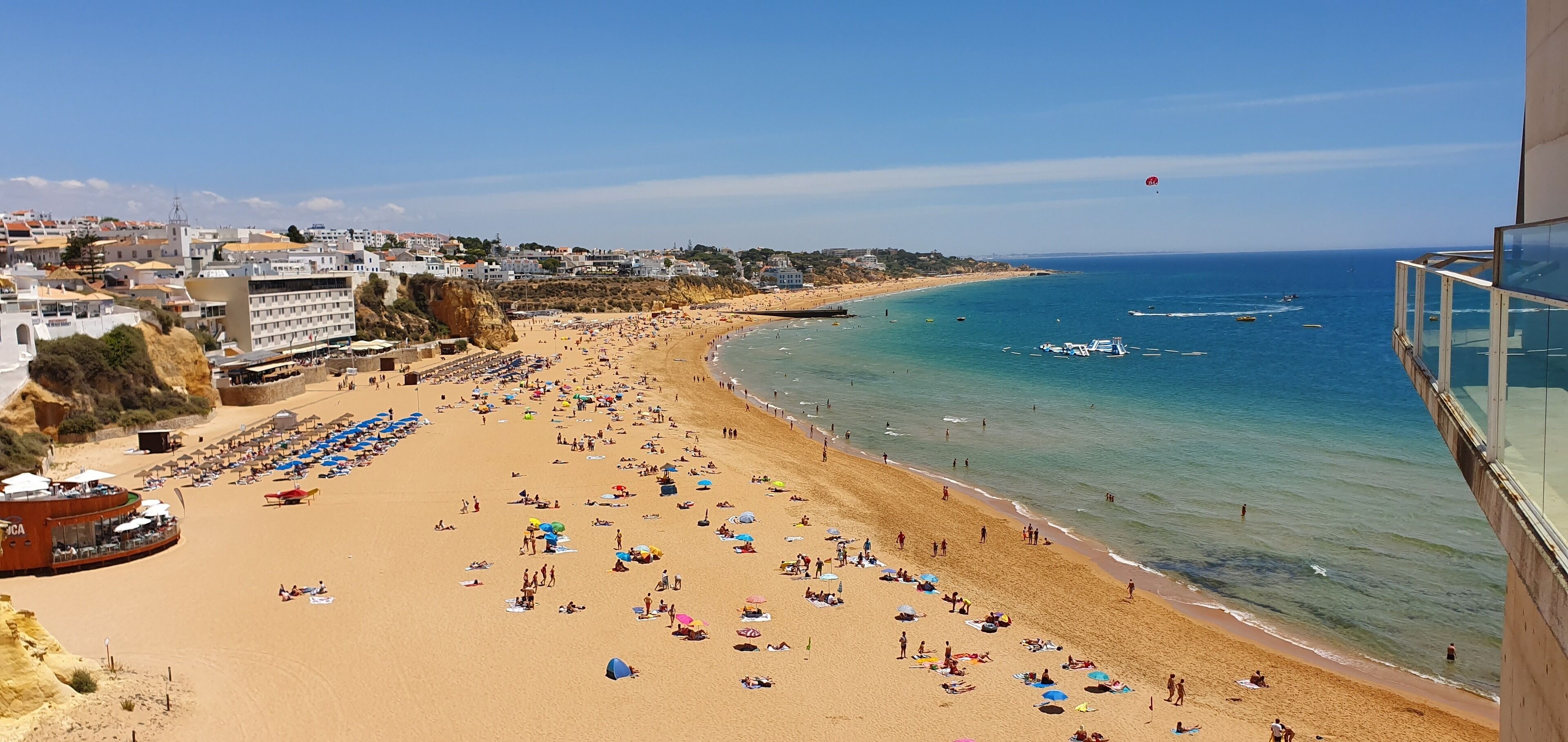 A beach with numerous umbrellas and people.