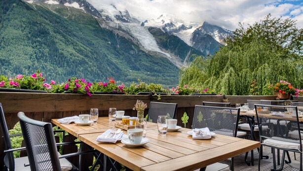 A table set for dining with a mountain view in the background. - Auberge du Bois Prin (Chamonix-Mont-Blanc)