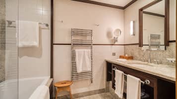 Un bagno con una vasca, un lavandino, uno specchio e un porta asciugamani.
