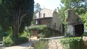 A stone house with a covered porch, surrounded by trees and a small garden. - PROVENCE stone house with private pool (Lorgues)