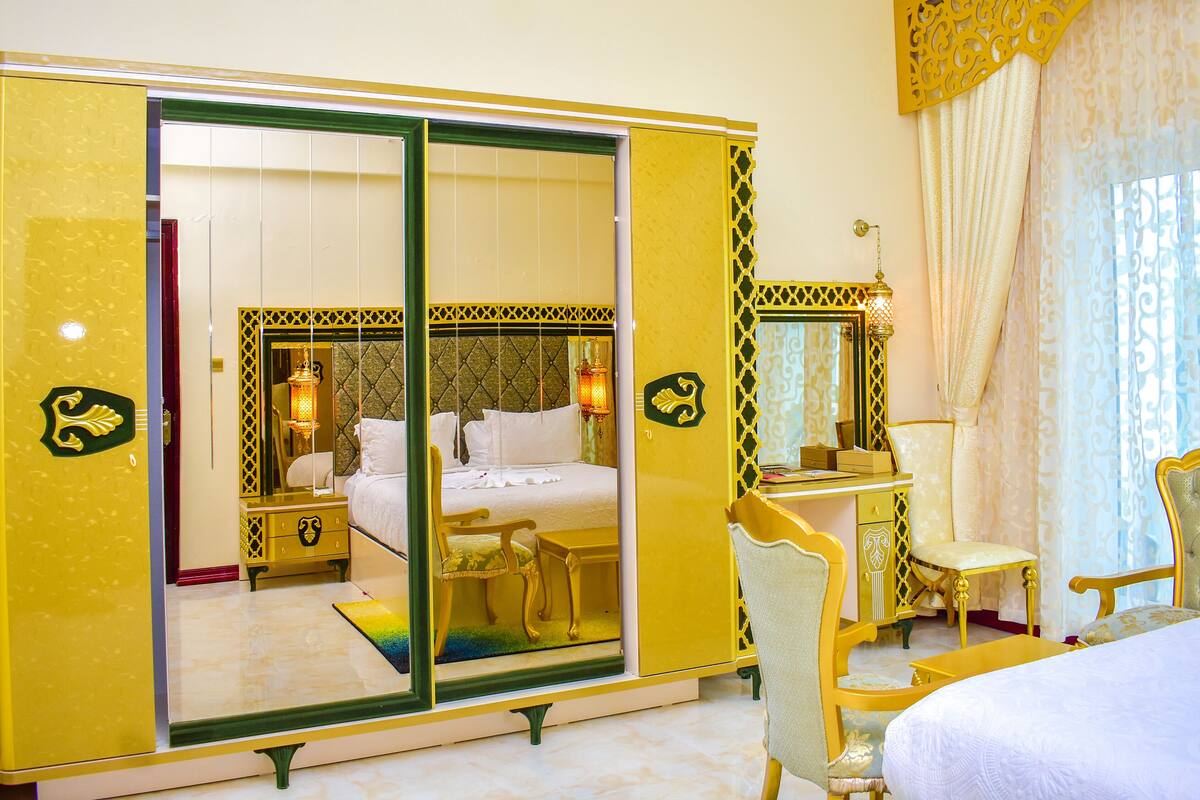 Une pièce comprenant une grande armoire à miroir, un lit, une table de chevet et une chaise.