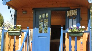 Eine Holzkonstruktion mit einer blauen Tür und einer kleinen Veranda.
