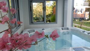 Ein Whirlpool mit Fensterblick auf Garten und Haus.