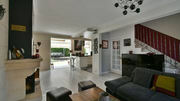 TV connectée, cheminée, table de tennis de table, livres