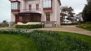 Ein großes, rosa-weißes Gebäude mit vielen Fenstern und einem überdachten Eingang.