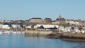 Eine Küstenstadt mit einem Yachthafen, historischen Gebäuden und einem markanten Kirchturm.