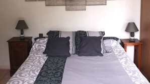 A bedroom with a bed, two nightstands, a wall decoration spelling "HOME" with a heart, and a hanging lamp. - Charming cottage with private pool in Black Périgord  (Le Bugue)