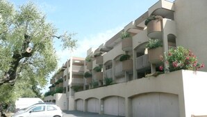 A multi-story residential building with balconies, a parking area, and a tree. - Charming, sunny, comfortable, 2 rooms Antibes, very close to the sea ON FOOT (Antibes)