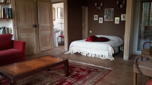 Relax in a traditional room with a large bed, wooden coffee table, and bookshelf.
