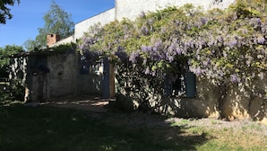 A rustic building with a garden area, a brick chimney, and a small window. - SAINT-SORNIN Atypical house with large plot 900 m2 closed ripe (Saint-Sornin)