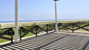 Een overdekt buitengebied met uitzicht op het strand.