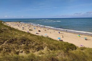 A beach with people, umbrellas, and tents. - Ile d'Oleron (17) House / Villa 8/9 pers, 500 m from the beach of Les Sables Vignier (Saint-Georges-D'oléron)