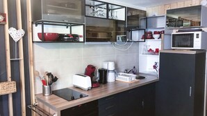 Una cocina moderna con armarios de madera, microondas, tostadora y cafetera.