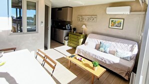Ein kompakter Wohnbereich mit Küchenzeile, Essplatz und Schlafzimmer.