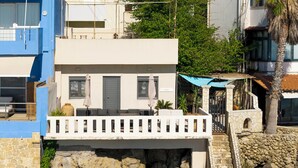 A coastal building with a balcony, stone walls, and a stone staircase leading to a door marked 'PENA'. - Villa Rena by the sea! (Arkoudi)