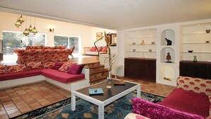 A living room with a sectional sofa, a coffee table, and a staircase leading to an upper level. - PROVENCAL MAS PISICINE JACUZZI CLIM 10 PEOPLE (JUAN LES PINS)
