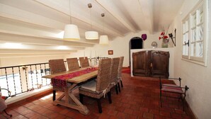 A dining area with a long wooden table, wicker chairs, and hanging pendant lights. - PROVENCAL MAS PISICINE JACUZZI CLIM 10 PEOPLE (JUAN LES PINS)