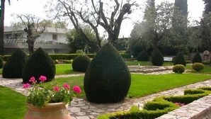 A garden with neatly trimmed hedges and a stone pathway.