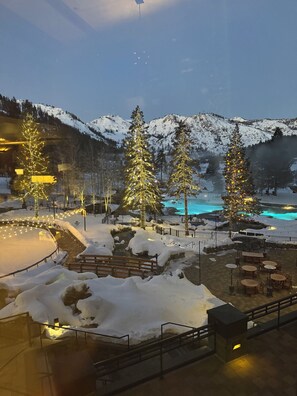 A snow-covered outdoor area with illuminated Christmas trees and a pool. - 2 BDRM Hyatt’s EVERLINE™️Resort@Spa! Amenities galore.Ski-inout,pools,hot tubs 😎 (Olympic Valley)