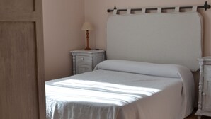 A bedroom with a bed, nightstand, and dresser.