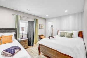 A hotel room with two beds, a nightstand, a chair, and a window with curtains. - The Grand Ranch: 6-BR Luxury Retreat with with Gazebo, Fire Pit & Outdoor Cinema (Raleigh)