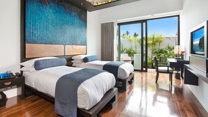 Une chambre d’hôtel moderne avec deux lits, un bureau et un balcon agrémenté de plantes.