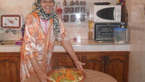 A kitchen with a microwave, a bowl of food, and various kitchen items on the counter.