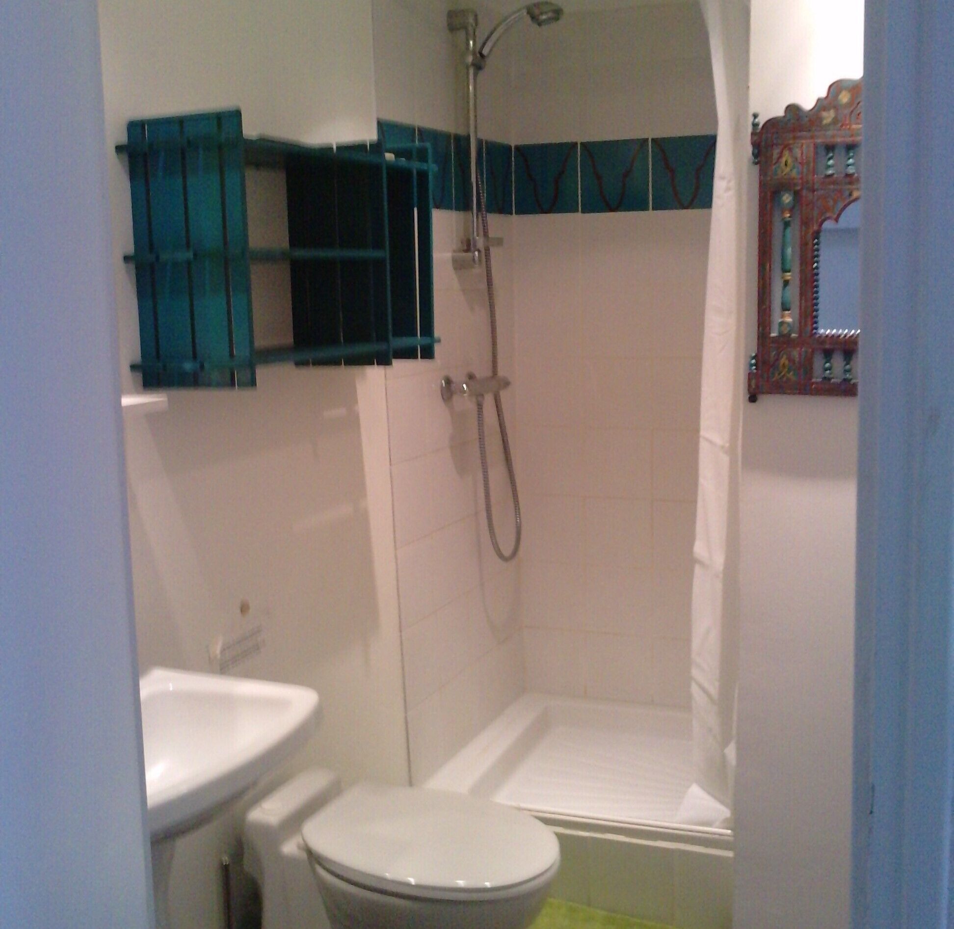 A bathroom with a toilet, sink, and shower.