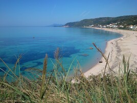 Στην παραλία, λευκή άμμος, ομπρέλες θαλάσσης