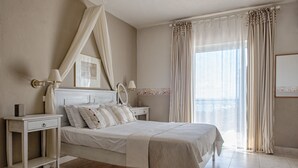 Un dormitorio con cama, mesitas de noche, dosel y ventana con cortinas.