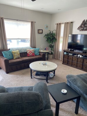A living room with a sofa, a coffee table, a television, and a cabinet. - Fall special, 15% off, book now before it's too late!! (Beach Haven)