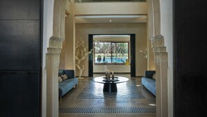 A spacious lobby with a high ceiling, a central coffee table, and two sofas. - ADNAA - Luxury Villa with 2 pools, sauna, hammam, tennis court & home cinema (Marrakech)
