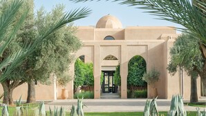 A building with a dome and arches, surrounded by greenery and palm trees. - ADNAA - Luxury Villa with 2 pools, sauna, hammam, tennis court & home cinema (Marrakech)