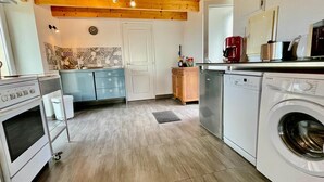 A kitchen with a stove, dishwasher, and washing machine.