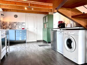 A compact kitchen with a washing machine, a coffee maker, and a microwave. - Reder Mor : maison de pêcheurs 250 m de la mer (SANTEC)