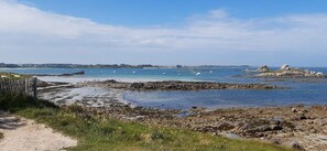 A coastal beach with rocky terrain, a sandy path, and clear blue waters. - Reder Mor : maison de pêcheurs 250 m de la mer (SANTEC)