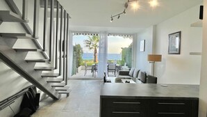 Un intérieur moderne avec un escalier, un coin repas et une vue sur l’extérieur.