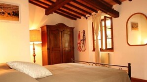 Ein Schlafzimmer mit einem Bett, einem Holzschrank und einem Fenster mit Vorhängen.