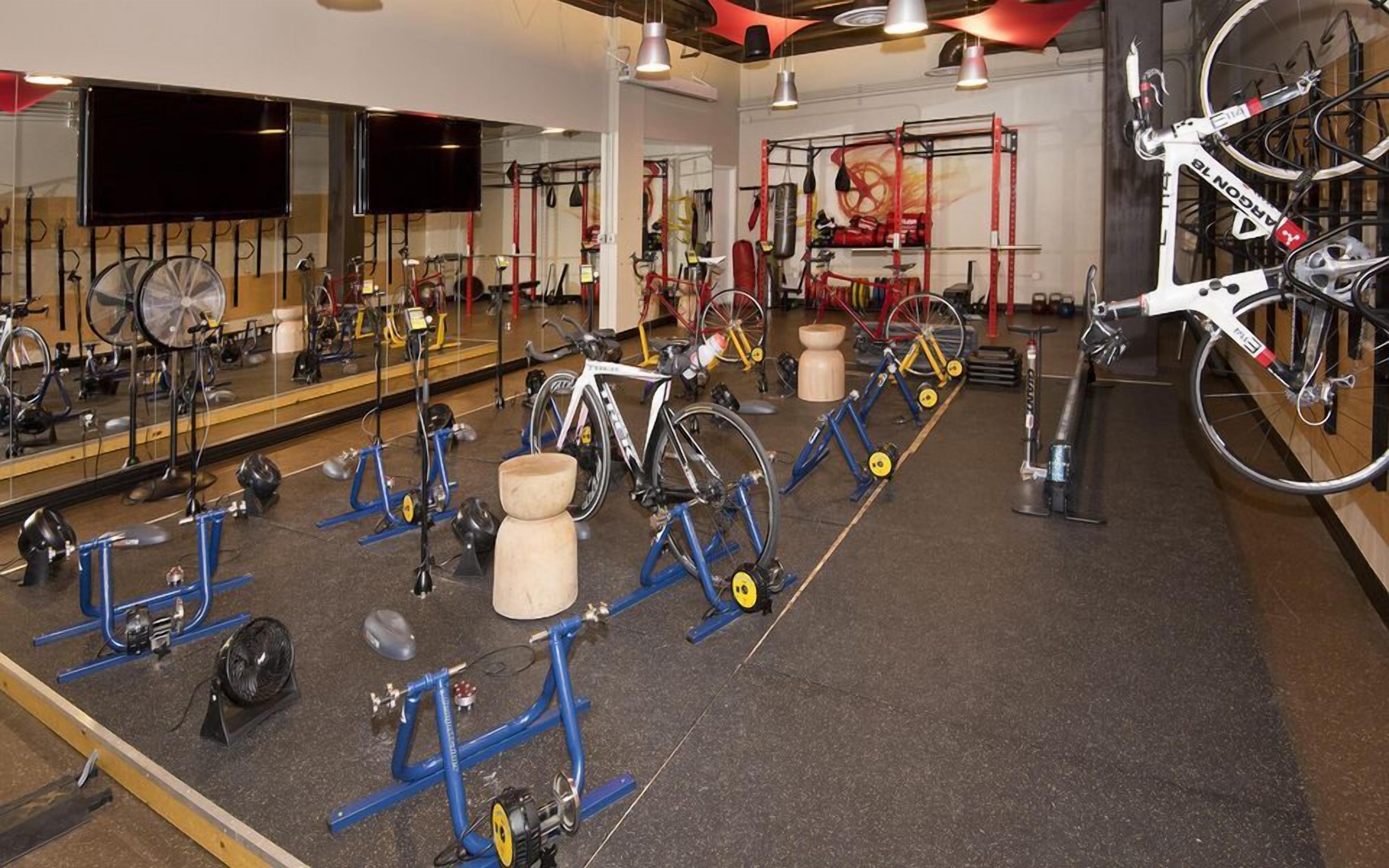 A gym with stationary bikes, weights, and exercise equipment.