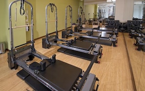 A Pilates studio with equipment arranged in rows.