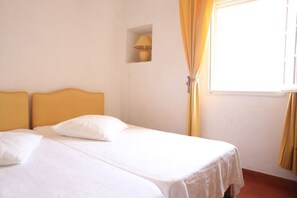 A single bed with a headboard, a small wall-mounted lamp, and a window with curtains. - Very nice duplex apartment, terrace and panoramic view in a medieval village (La Cadière-D'azur)