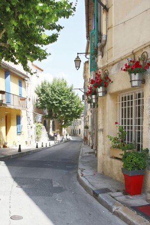 A narrow street lined with buildings, some with balconies and flower boxes. - Very nice duplex apartment, terrace and panoramic view in a medieval village (La Cadière-D'azur)