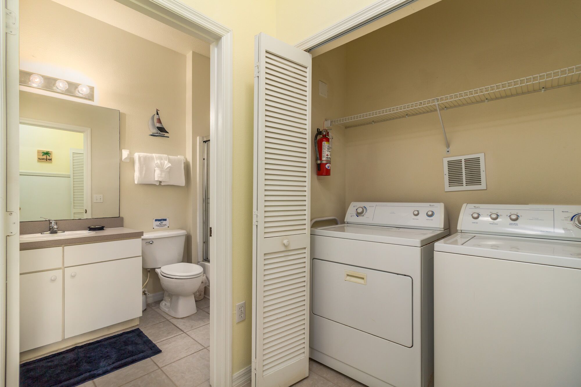 A compact laundry room with a washing machine, dryer, and a toilet.