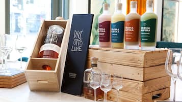 Eine Auswahl an Crema Alpina Likören in Holzkisten, zusammen mit einer schwarzen Schachtel und einer Flasche Distilleria Marzadoro.