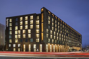 Ein modernes Hotel mit mehreren Etagen, großen Fenstern und einem markanten Eingang.